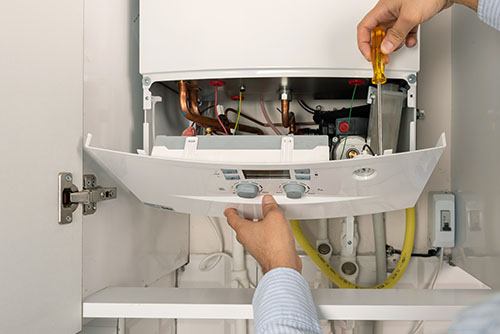 Heating technician repairing a residential boiler in North Highlands
