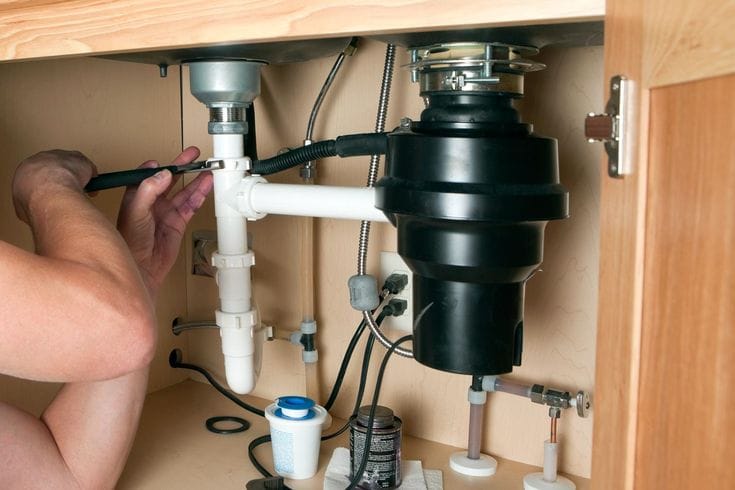 Plumber repairing a garbage disposal in North Highlands