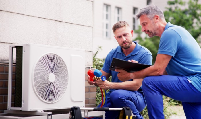 HVAC technicians installing an outdoor air conditioning unit in North Highlands